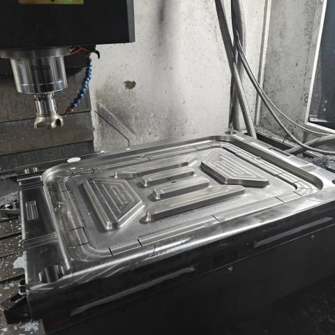 Large sheet metal press die tool set up on a machine bed