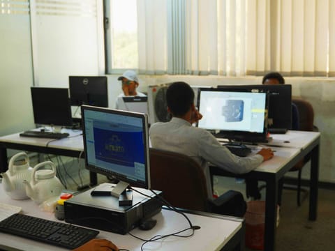 Engineers working at computer workstations in the ZG design office, with a 3D CAD model on screen