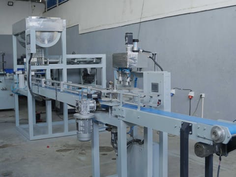 Packaging line with product hopper and conveyor running through the workshop