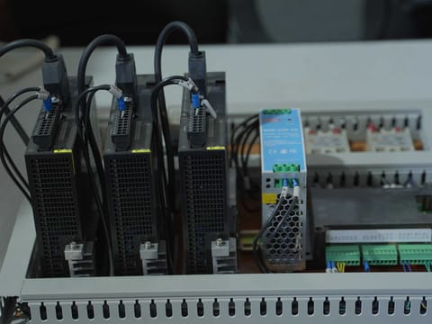 Interior of a control cabinet showing variable frequency drives and wiring terminals